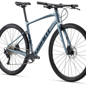 Giant Fastroad AR 1 2023 jalgratas Aged Denim värvuses, millel on mustad rehvid ja ketta pidurid.